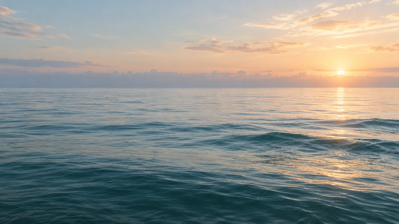 Calm sea at dawn beneath a pale sky